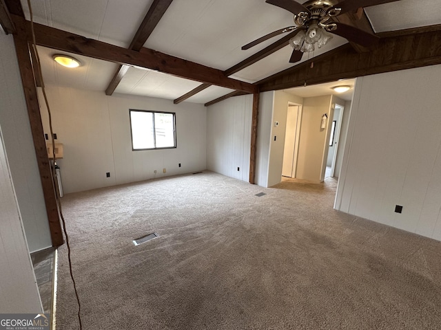 carpeted empty room with ceiling fan and lofted ceiling with beams