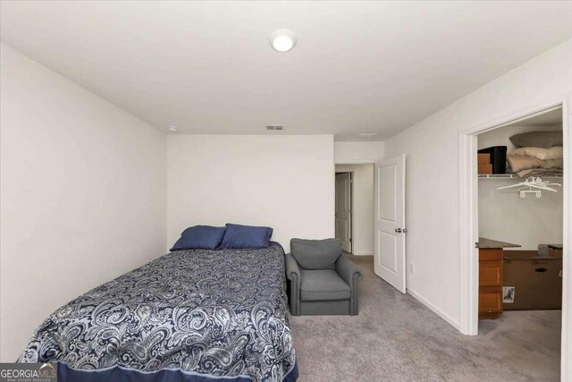 bedroom with light colored carpet and a closet