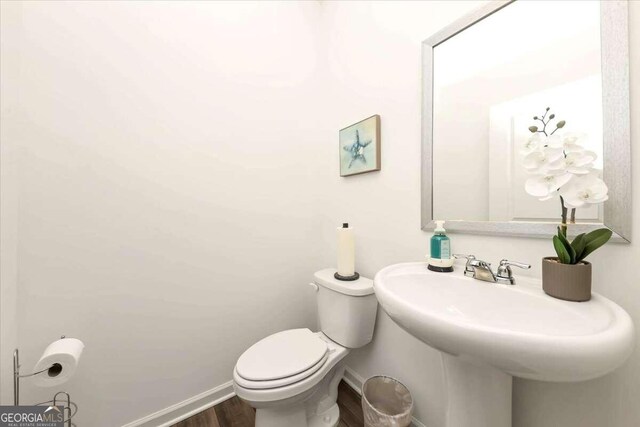 bathroom featuring toilet, sink, and hardwood / wood-style flooring