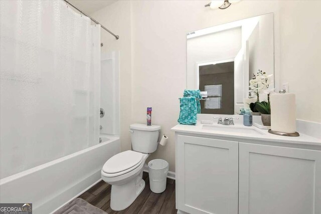 full bathroom featuring vanity, shower / tub combo with curtain, toilet, and hardwood / wood-style flooring