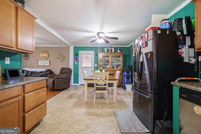 kitchen featuring ceiling fan, stainless steel appliances, crown molding, and light carpet