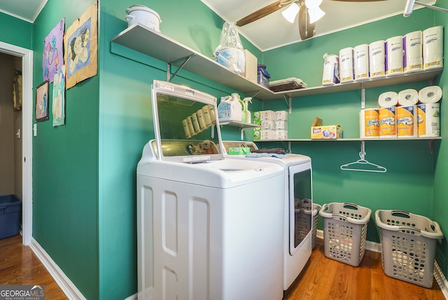 washroom with crown molding, ceiling fan, washing machine and clothes dryer, and hardwood / wood-style flooring