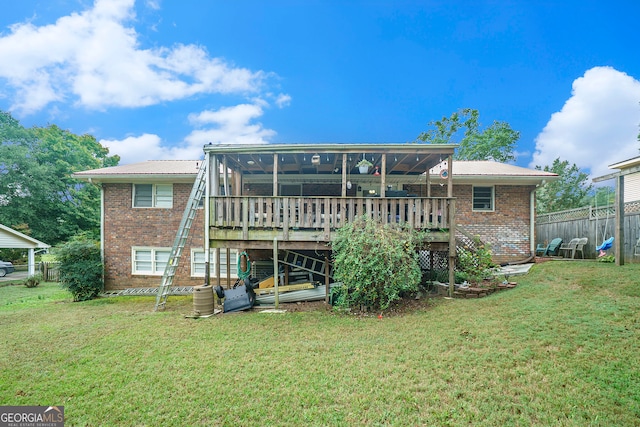 rear view of property featuring a wooden deck and a yard