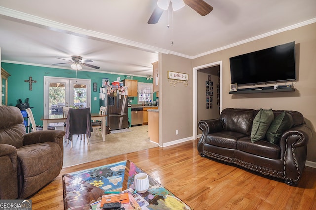 living room with ornamental molding, light hardwood / wood-style floors, ceiling fan, and sink