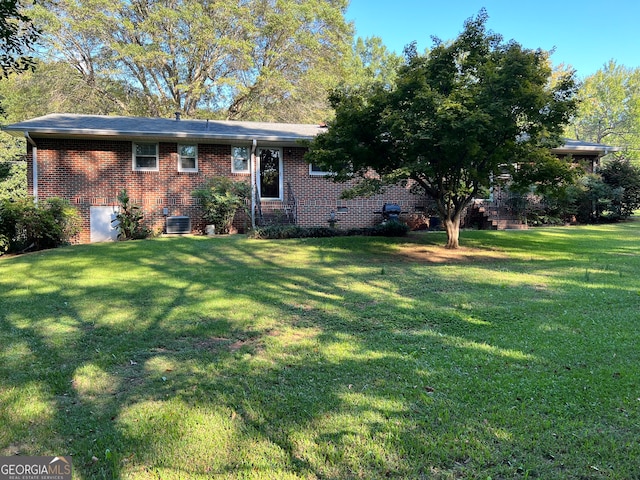 view of front facade with a front yard and central air condition unit