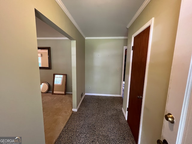 hallway with ornamental molding and dark colored carpet