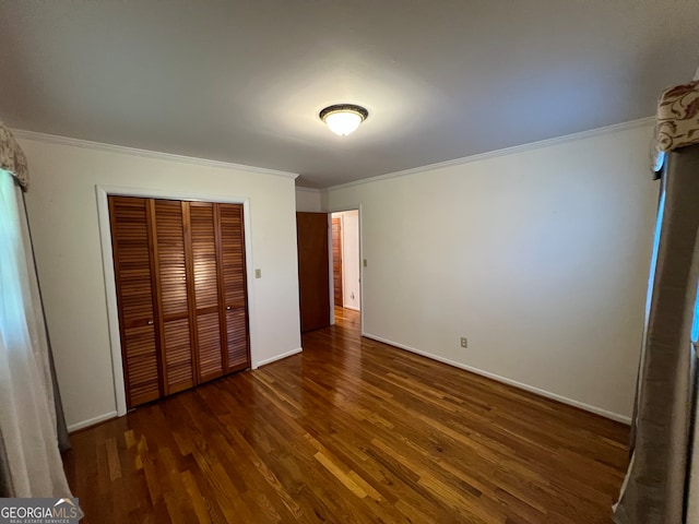 unfurnished bedroom featuring a closet, crown molding, and dark hardwood / wood-style flooring