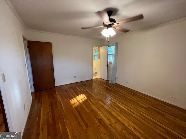 unfurnished bedroom with ceiling fan, ornamental molding, and dark hardwood / wood-style flooring