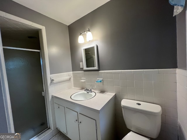 bathroom featuring tile walls, vanity, toilet, and a shower with door