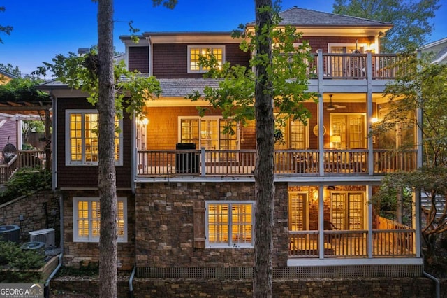 back house at dusk with a balcony