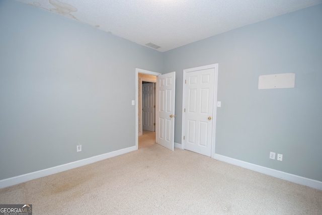 interior space with light carpet and a textured ceiling