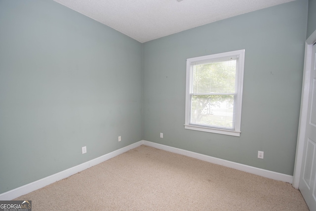 carpeted empty room with a textured ceiling