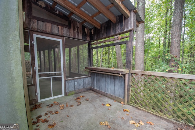 unfurnished sunroom with vaulted ceiling with beams