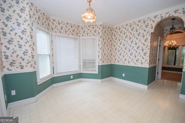 empty room featuring an inviting chandelier and crown molding