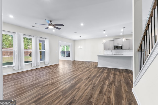 unfurnished living room featuring dark hardwood / wood-style floors and ceiling fan