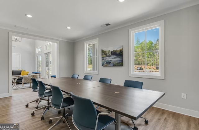 office area with a wealth of natural light, crown molding, and light wood-type flooring