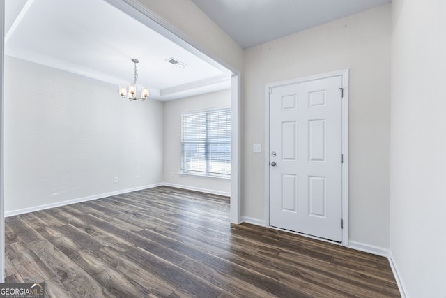 foyer entrance with an inviting chandelier and dark hardwood / wood-style flooring