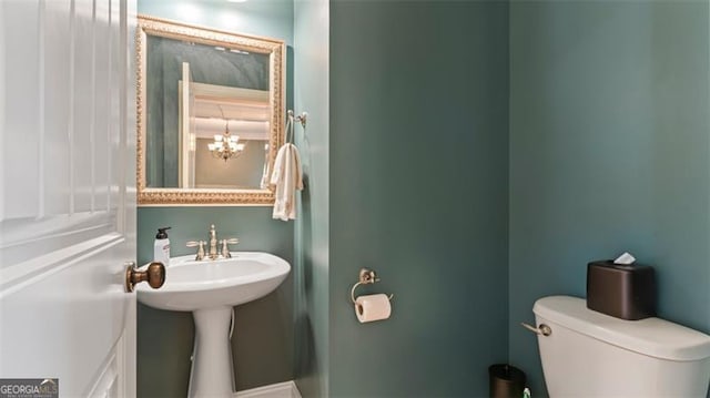 bathroom featuring a notable chandelier and toilet