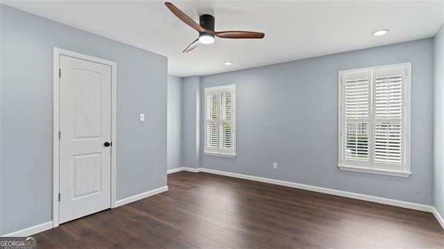 spare room featuring ceiling fan and dark wood-type flooring