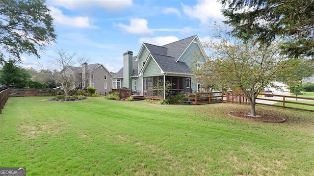 view of side of property with a sunroom and a yard