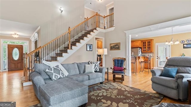 living room featuring a notable chandelier, light wood-type flooring, and bar