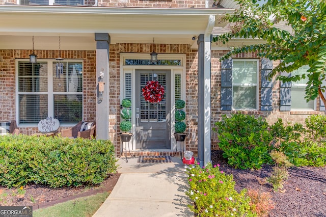 view of exterior entry featuring covered porch