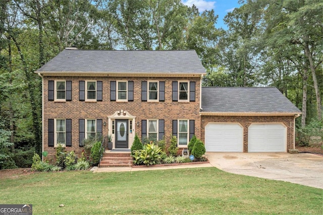 colonial-style house featuring a front yard and a garage