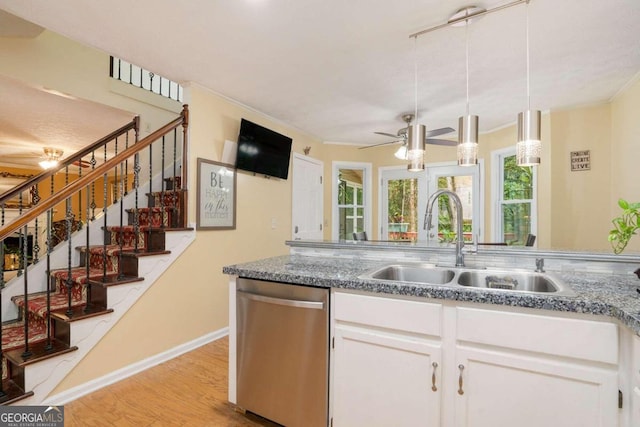 kitchen with light hardwood / wood-style flooring, white cabinetry, sink, and stainless steel dishwasher