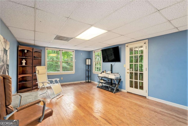 sitting room featuring a drop ceiling and hardwood / wood-style floors