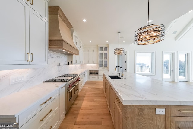 kitchen featuring sink, white cabinetry, a spacious island, and custom exhaust hood