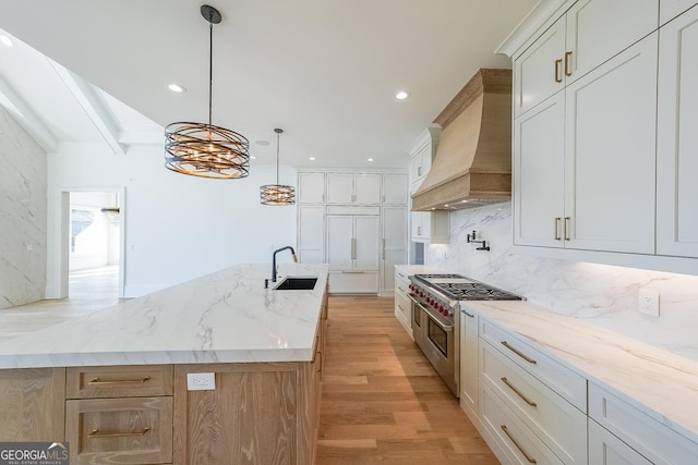 kitchen with premium range hood, white cabinetry, high end appliances, and light hardwood / wood-style flooring