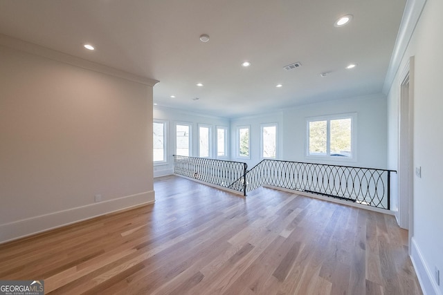 unfurnished room with light hardwood / wood-style flooring and ornamental molding