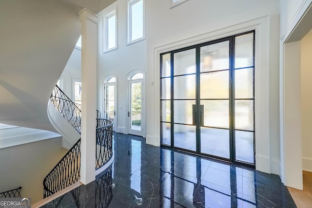 entrance foyer with dark hardwood / wood-style flooring and a towering ceiling