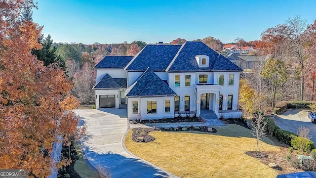 french country inspired facade featuring a porch, a garage, and a front lawn