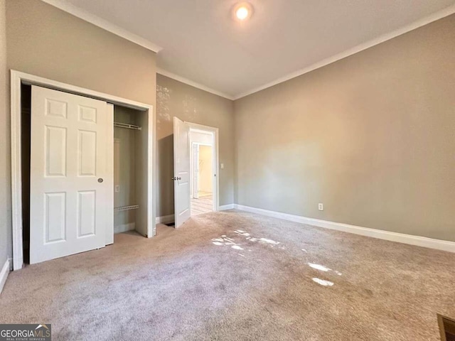 unfurnished bedroom with ornamental molding, a closet, and carpet flooring