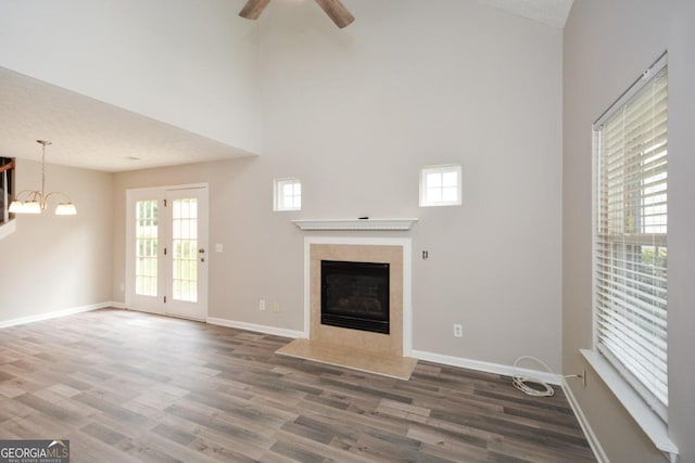 unfurnished living room with dark hardwood / wood-style floors, a high end fireplace, and plenty of natural light