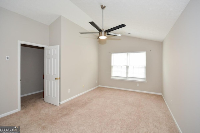 carpeted empty room featuring lofted ceiling and ceiling fan