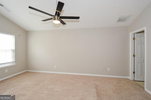 unfurnished room featuring lofted ceiling, ceiling fan, and light colored carpet