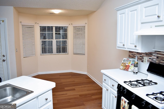 kitchen featuring white gas range oven, white cabinetry, hardwood / wood-style flooring, exhaust hood, and a textured ceiling