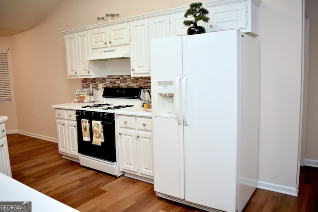 kitchen with hardwood / wood-style floors, white appliances, and white cabinetry