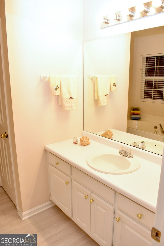 bathroom with a bath, hardwood / wood-style flooring, and vanity