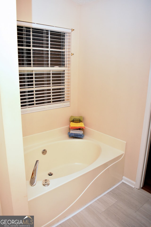 bathroom featuring hardwood / wood-style flooring and a tub