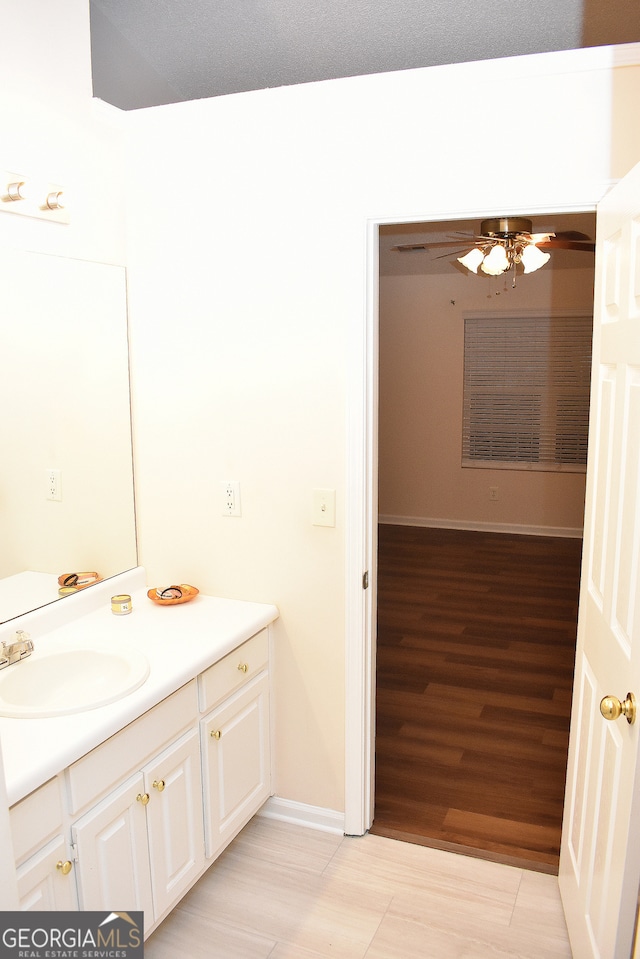 bathroom with hardwood / wood-style floors, vanity, and ceiling fan