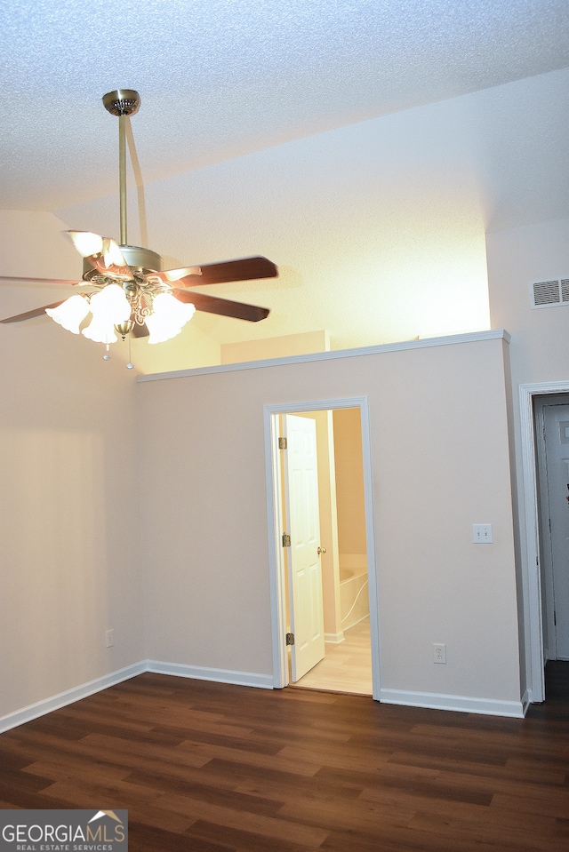 empty room featuring dark wood-type flooring, a textured ceiling, and ceiling fan