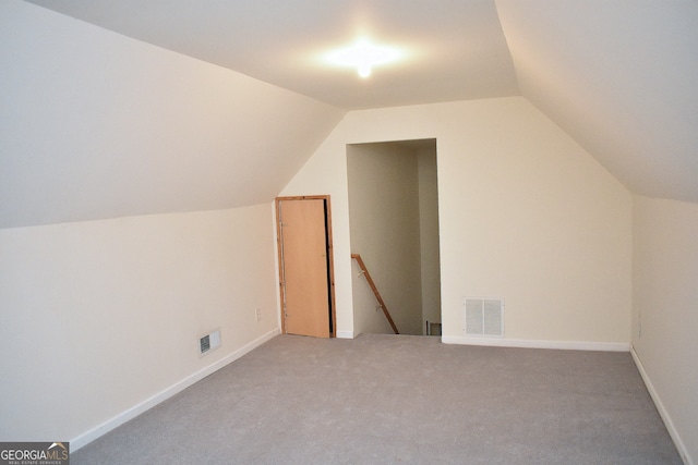 bonus room with lofted ceiling and carpet flooring