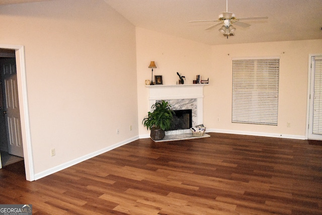 unfurnished living room with ceiling fan, a premium fireplace, and dark wood-type flooring