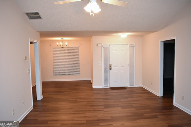 unfurnished room with ceiling fan with notable chandelier, dark hardwood / wood-style flooring, and a textured ceiling