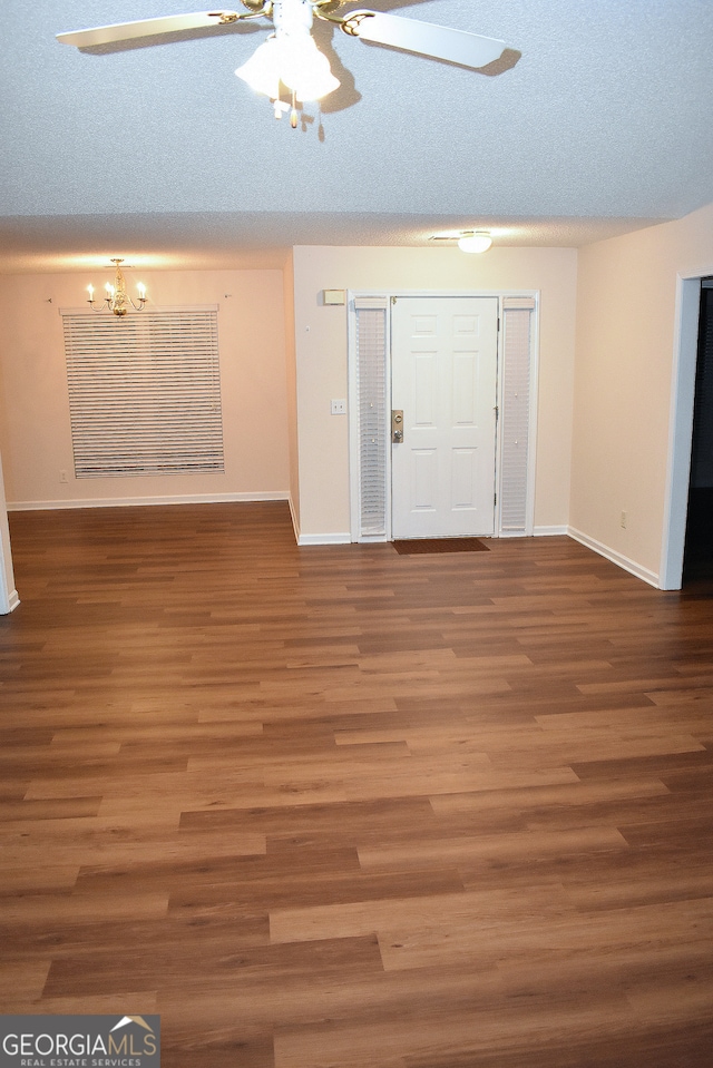 foyer with wood-type flooring, a textured ceiling, and ceiling fan with notable chandelier