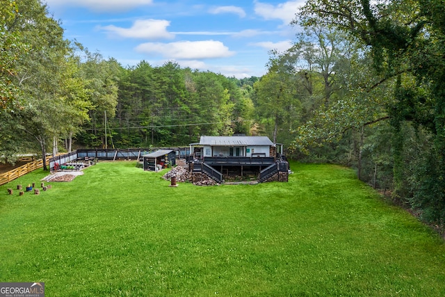 rear view of property featuring a lawn and a deck