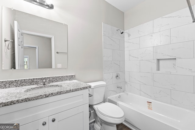 full bathroom with tiled shower / bath combo, vanity, and toilet